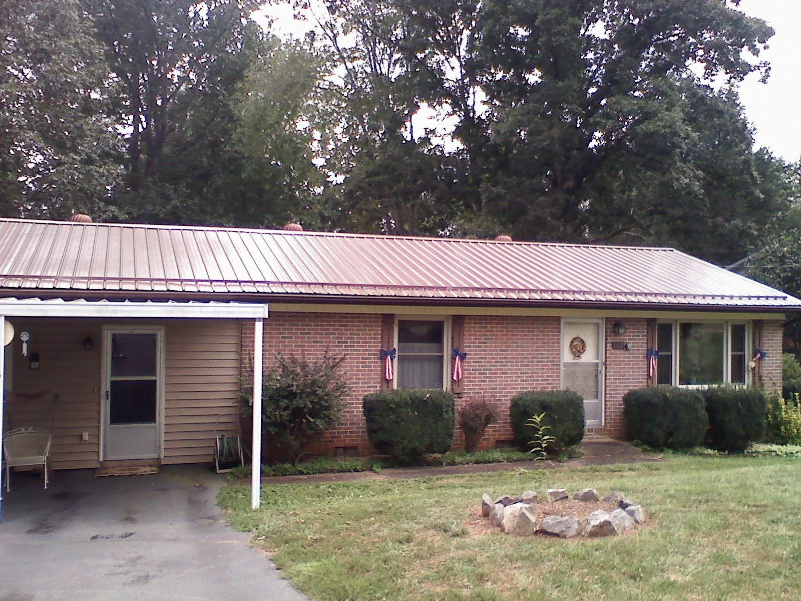 Bronze metal roof and carport on a brick ranch home — Roof Repair work by our crew in Decorah